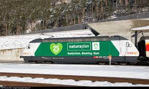 re 460 001 in coop naturaplan publicity paint scheme is leaving the gotthard base tunnel at rynacht near erstfeld with th train train tracks locomotive train