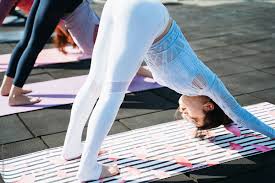 Young Women Are Bending Over To Do Yoga by Stocksy Contributor zheng  long - Stocksy