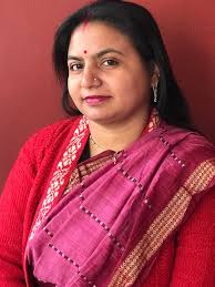 Dear middle aged indian woman looking satisfied in a green sari