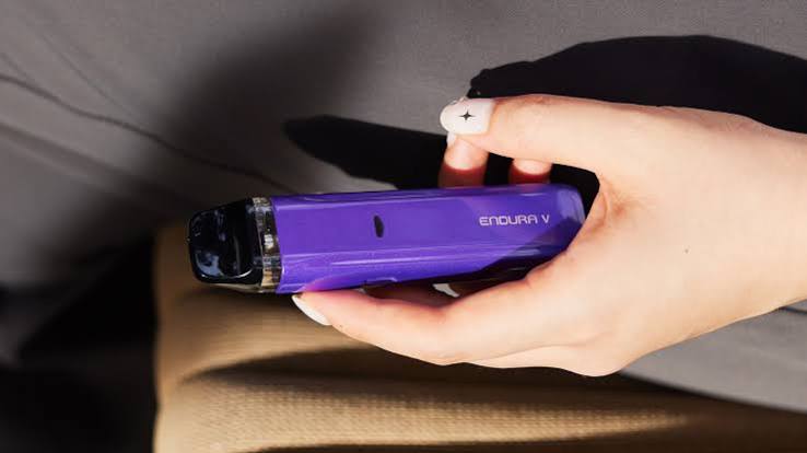 Close-up of a hand holding a purple Innokin Endura V refillable pod vape kit  VapeFeat product review