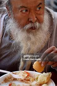 John Nieblas eats his free Thanksgiving dinner in the parking lot of...  News Photo