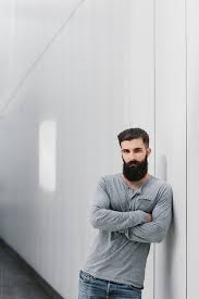 It's more commonly used in phrases like pressed up against than with a word like leaning. Handsome Young Man Leaning Against A Gray Wall By Amir Kaljikovic Beard Guy