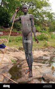 A Suri (Surma) naked young man body painted with mud, Ethiopia Stock Photo  - Alamy