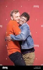two men, cutest cuddling gay couple ever. shot in studio (pink background),  smiling and happy together. cuteness overload Stock Photo - Alamy