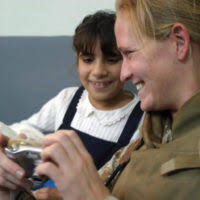 A young vision-impaired girl smiles after receiving a gift from US Marine  Corps (USMC) Marines, Alpha Company (A CO), Battalion Landing Team (BLT),  1ST Battalion (BN), 4th Marine Regiment, 11th Marine Expeditionary
