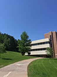 Green Grass And Pine Trees Surround The Rutger Erickson Academic Building On Campus In Ironwood Michigan Summer Sun Community College Campus Pure Michigan