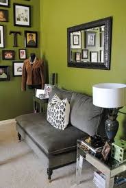 Bring in black hue by painting one of the living room's walls. Little Grey Couch Olive Green Walls And Wall Of Frames By Lucinda Green Walls Living Room Living Room Green Accent Walls In Living Room