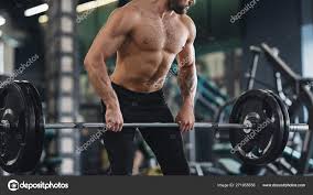 Strong man with naked muscular body exercising with heavy barbell Stock  Photo by ©Milkos 271955556