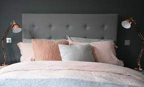 They anchor the bed with its lovely gray upholstered headboard and its group of subtly colored pillows. Grey Room Bedroom Copper Pink Flat Design House N Decor