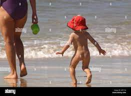 Baby laufen hinter Mutter nackt am Strand Stockfotografie - Alamy