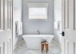 Slate herringbone pattern floor tiles in a transitional bathroom includes a seamless glass shower with large white and gray marble staggered wall tiles. Wood Herringbone Bathroom Walls Design Ideas