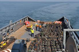 Personnel contracted by the Supervisor of Salvage and Diving division of  Naval Sea Systems Command prepare to deploy inflatable oil booms aboard the  supply vessel M/V John Coghill.