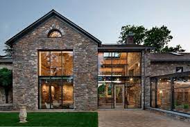 A traditional house that meanders around courtyards built as though it where built in stages over time. Modern Redesign Of Old Country Home With Antique Stone Walls And Exposed Ceiling Beams