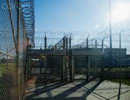 Prison Fence Locked Gate And Barbed Wire At Correctional Facility Prison Buildings And Exercise Yard High Security Sombras Parque Jurasico Luces