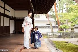 This photo is another example of an inappropriate mother/son picture since they're both wearing headgear (along with the kid's sister). A Young Japanese Boy And His Mother Wear Traditional Kimono Dress Japanese Mother Fashion Mother Fashion Traditional Kimono
