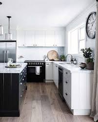 Bowls of fresh fruit on the marble countertop add a splash of color against the grays and the neutral tile floor. Kitchen Black Appliances
