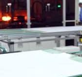 modern automatiserad sol- energi produktion. fabrik producerar sol-  paneler. industriell robot maskineri arbetssätt på en sol- panel växt.  vertikal