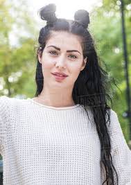 Bun hairstyles are always in the top of the hairstyles ideas. Portrait Of Young Stylish Woman With Long Black Hair And Hair Buns In City Park Stock Photo Dissolve