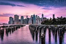 The financial district skyline is reflected in the pool of the los 10x8 (25x20cm) print (#19793201). New York City Skyline Sunset Hues Photograph By Susan Candelario