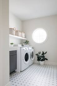 Laundry Room Besides Featuring A Beautiful Round Window This Upper Level Laundry Room Also Fe Laundry Room Inspiration Laundry Room Colors White Laundry Rooms