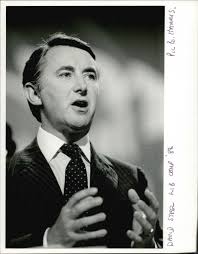 David Steel standing while giving a speech in a conference meeting. -