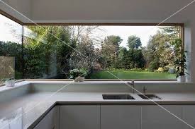 Panoramafenster Mit Blick In Den Garten In Heller Designer Kuche Aus Corian Haus Design Haus Innenraume Haus Innenarchitektur