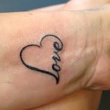 Girls Heart Wrist Tattoo With Love Written In Outline Love Wrist Tattoo Tattoo Designs For Girls Tattoos