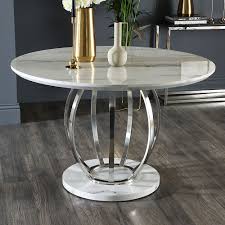 A table has a square top of faux marble in browns and tall straight square brown legs. Savoy Round White Marble And Chrome 120cm Dining Table Furniture And Choice