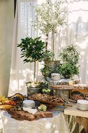 A charcuterie board is a simple, rustic and visual way to display many types of meats together. Rustic Charcuterie Display With Olive Trees Wedding Buffet Table Wedding Buffet Displays Buffet Decor