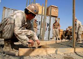 Steelworker Constructionman Jason Dalton and Builder 3rd Class Patrick  Schneider level a concrete pad during a training day at Camp Krutke.
