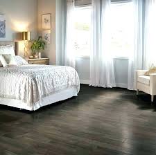 Bed with dark blue pillows and grey duvet and blanket next to window. Bedroom Furniture For Dark Wood Floors Bedroom Furniture Ideas