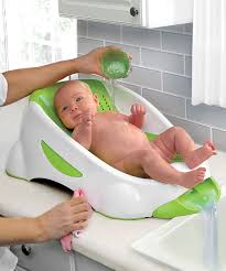 Use one hand to support baby's head, then slowly lower them. Green Munchkin Clean Cradle Tub Might Be A Better Way To Go With Baby No 2 Baby Gadgets Baby Bath Baby Bath Tub
