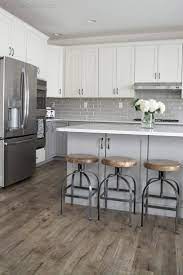 Wpc vinyl and spc vinyl. Vinyl Plank Flooring And Wood And Metal Counter Stools In Grey And White Kitchen Wood Floor Kitchen White Kitchen Design Gray And White Kitchen