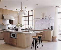 Long kitchen highlighted by natural light wood cabinets and drawers, along with matching stone backsplash and flooring. Kitchen Trends Natural Wood Cabinets Apartment Therapy