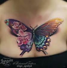 The tattoo is created using black and gray ink and is located under the wearer's right breast. Stunning Butterfly Tattoo On Chest By Levgen Feminine Tattoos Tattoos Body Art Tattoos