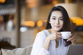 Smiling woman drinking coffee in your room. Chinese Woman Drinking Coffee In Cafe Looking In Camera Hot Drink Stock Photo 183035446