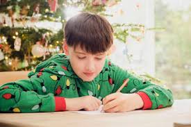 Klick the pic below in case you missed some Cute Boy Writing On Paper At Table With Christmas Tree In Background At Home Stockphoto