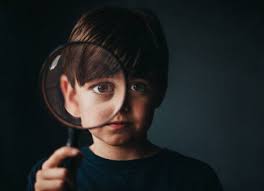 Search for magnifying glasses with us. Portrait Of Young Boy Holding A Magnifying Glass Over One Eye Stockphoto