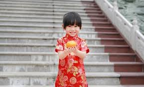 Célébrez la culture classique avec des vêtements asiatiques traditionnels ! Enfant Asiatique Mignon En Robe Traditionnelle Chinoise Avec Tenue Orange Sacree Au Temple Chinois Photo Premium
