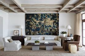 House construction used to always feature beams of great solid wood that carried the weight of the upper floor, or ceiling, transferring the stress to the walls. Living Room Neutral Tapestry White Sofa Modern Sisal Rug Exposed Ceiling Beams Andrew Howard Interior Design Katie Considers