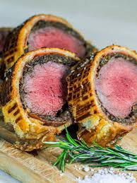 Beef tenderloin fillet, coated with mustard, mushroom duxelles, ham, wrapped in puff pastry and baked. Beef Wellington Jacob Jorgsholm