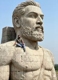 Prompt: Transform the person from the attached photo into a scene where he  is sitting