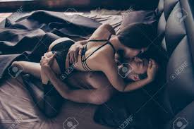 情熱的な美しいいたずらな性的カップルの上のビュー、女性の支配と挑発彼女はベッドの上でハンサムな男にキスし、レースの黒いエロティックな下着を着ていますの写真素材・画像素材  Image 93962931