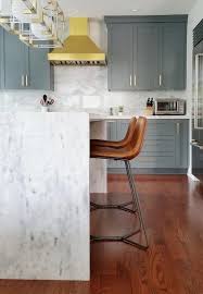 Make a statement with one of our hundreds of amazing 24 to 26 inch counter stools for kitchen use. Contemporary Gray And Gold Kitchen Features Cb2 Roadhouse Leather Bar Stools Placed In Front Of A Marble Waterfal Kitchen Concepts Kitchen Stools Home Kitchens