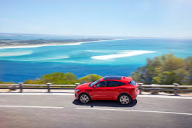 Red Suv On Road With Overlooking Of Ocean Hd Wallpaper Wallpaper Flare