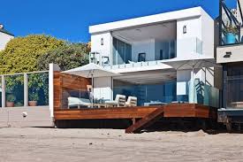 They let tons of natural light inside the house and they also welcome the views in. Beautiful Modern House With Wooden Terrace Connected To The Beach California
