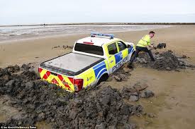 police car sinks into sand and gets