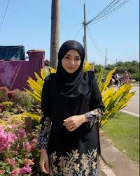 Woman in black hijab standing in front of a flower garden - SeaArt AI