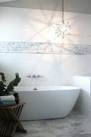 Beautiful Bathroom With Sloped Ceiling Over Subway Tiles Accented With A Mini Marble Brick Tile B Subway Tiles Bathroom Amazing Bathrooms Wall Mount Tub Faucet