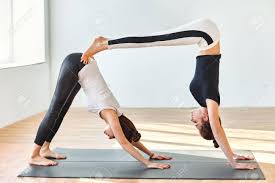 Two Young Women Doing Yoga Asana Double Downward Dog Adho Mukha Stock Photo Picture And Royalty Free Image Image 60825062